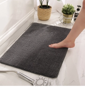 Close-up of deep grey rectangular non-slip bathroom mat with soft plush texture
