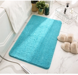 Macro shot of fluffy bright blue chenille bath mat showing soft high-density texture