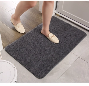 Close-up of dark grey plush bath mat showing soft polyester fibers and thick stitched edges