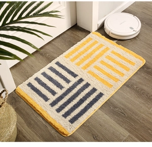 Close-up of geometric striped tufted kitchen mat on wooden floor with a vacuum robot