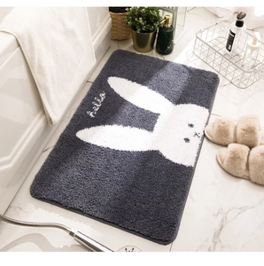 Close-up of thick plush bathroom mat with cute white rabbit pattern and grey background