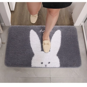 Close-up of the thick grey plush texture and cartoon rabbit design on the bath mat