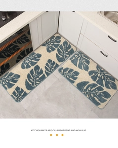 Detalle de alfombras de cocina antideslizantes con estampado de hojas de monstera azul sobre marfil