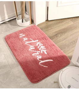 Dettaglio della trama del tappeto rosa con scritte natural bianche e motivi di foglie