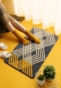 Close-up of thick absorbent bathroom mat with grey and yellow geometric diamond patterns