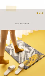 Detail of plush geometric diamond pattern bath mat in grey and mustard yellow tones