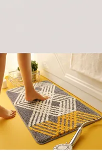 Close-up of geometric bath mat with soft microfiber texture next to a bathtub