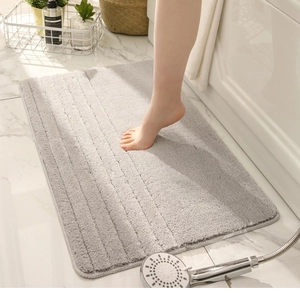 Primer plano de alfombra de baño gris gruesa con textura de felpa a rayas y absorbente