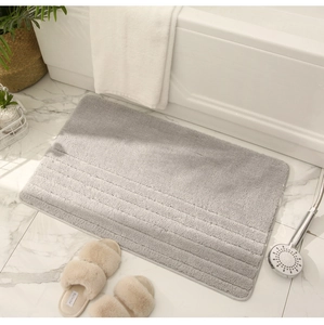 Primer plano de alfombra de baño gris claro con textura 3D de rayas y felpa gruesa