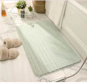 Detalle de alfombra de baño de microfibra verde claro con rayas antideslizantes