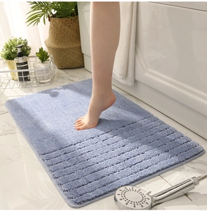 Detail of light blue chenille bath mat with ribbed texture and thick absorbent fibers