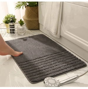 Detailed texture of thick dark grey non-slip bathroom mat with striped pattern