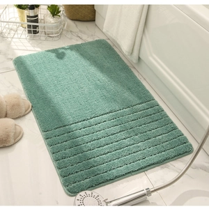 Close-up of sage green anti-slip bath mat with striped backing in a modern bathroom
