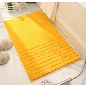 Detailed close-up of yellow striped chenille bath mat showing plush absorbent texture