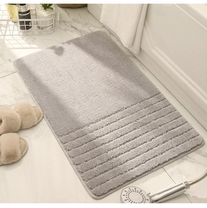 Detail of light grey non-slip bath mat with thick vertical stripes on marble floor