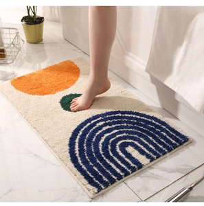 Close-up of geometric tufted bathroom mat with abstract arch pattern on marble floor