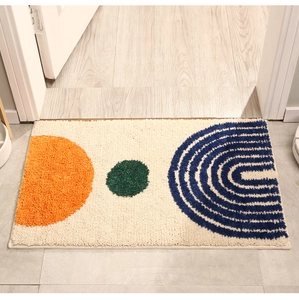 Macro detail of tufted geometric entryway mat showing soft texture and precise stitching