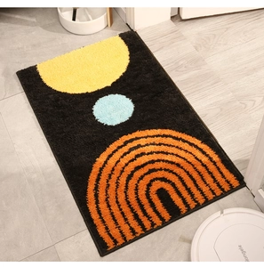 Detail view of thick tufted indoor mat featuring modern abstract geometric arch patterns