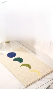 Détail du tapis de bain moelleux avec motif artistique de phases de lune colorées