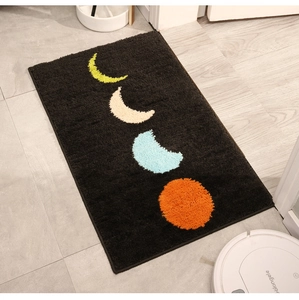 Détail du tapis de bain épais noir avec phases de lune montrant la texture douce et pelucheuse