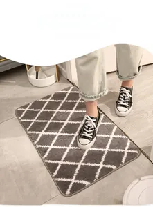 Thick grey absorbent entryway mat with white geometric diamond patterns on floor