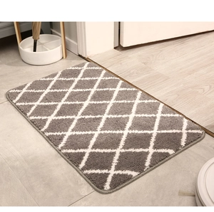 Detailed view of the thick plush texture and grey diamond pattern on this indoor door mat