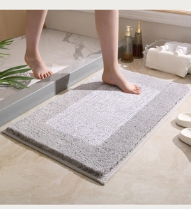 Detalle de alfombra de baño gruesa de microfibra gris y blanca con textura suave