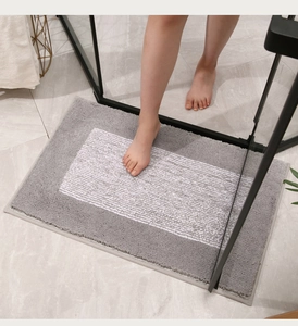 Detalle macro de la alfombra de baño gruesa con rayas grises y blancas sobre suelo