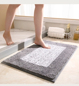 Primer plano de alfombra de baño gruesa gris y blanca con textura de microfibra
