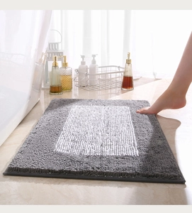Primer plano de alfombra de baño absorbente gruesa con textura de felpa gris y blanca