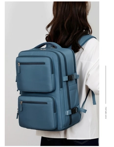 Blue-grey business travel backpack with multi-layer zipper pockets worn by a person