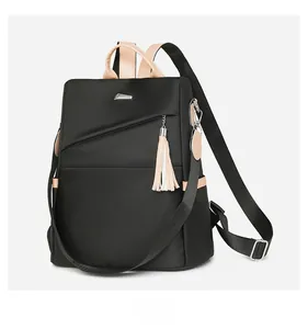 Side view of large nylon backpack featuring brown straps and tassel charm detail