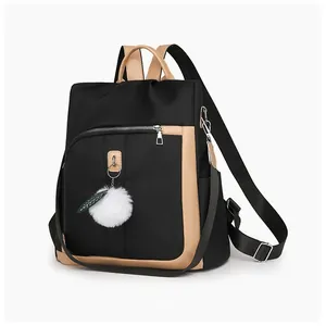 Vista laterale dello zaino in nylon nero con finiture marroni e ciondolo di peluche