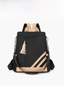 Detail of black nylon backpack featuring contrast stripes and stylish tassel charm