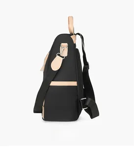 Side view of black nylon backpack featuring brown leather trim and metal hook detail