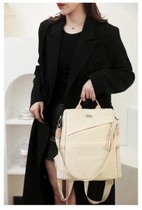 Modern beige nylon backpack with tassel detail shown on a model in a minimal suit