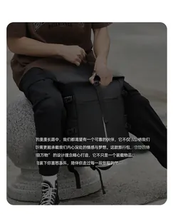 Outdoor shot of a black roll-top backpack with adjustable straps and buckles
