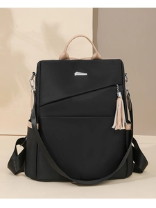 Detail of nylon backpack showing khaki trim, side pockets, and metal logo accent