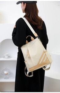 Detail of beige PU leather backpack with contrast stripes and tassel on the side pocket