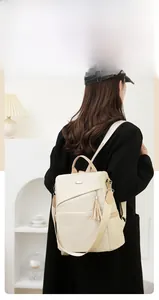 Detail view of stylish nylon backpack with contrast straps and tassel on black coat
