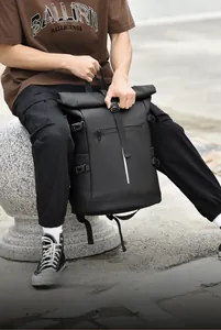 Close-up of black roll-top backpack with waterproof fabric and front zipper pocket
