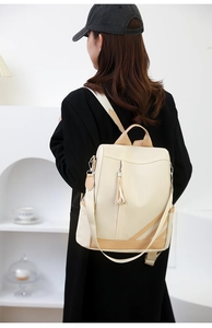 Close-up of contrast faux leather backpack with fringe detail and adjustable straps