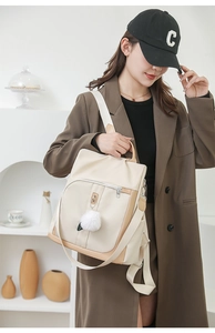 Dettaglio zaino moda beige e marrone con pompon morbido e ampia tracolla in tessuto