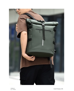 Detail of roll-top backpack with reflective strip and waterproof fabric in dark green