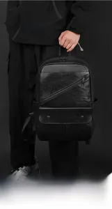 Detail of ergonomic handle and premium lychee texture on black faux leather backpack