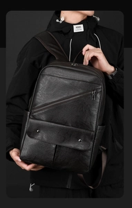 Detailed view of deep brown leather backpack with metallic zipper and textured surface