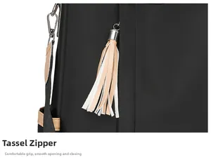 Detail of smooth tassel zipper on a black commuter backpack with silver metal hooks