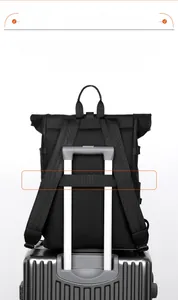 Detail showing the travel-ready back strap of the backpack secured to a luggage handle