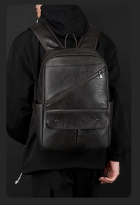 Detail view of the sleek matte black PU leather surface and diagonal zipper pocket