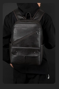 Close-up of black PU leather backpack with diagonal zipper and flap pocket texture